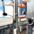 Ein Abwassertechniker reinigt mit industrielle Ausrüstung eine Wasseraufbereitungsanlage im Freien.