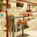 Ein Abwassertechniker führt im Labor eine Analyse mit Messzylindern durch.