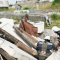 Das Bild zeigt Rettungskräfte in Schutzkleidung, die bei einer Such- und Bergungsaktion in einem Trümmerfeld arbeiten.
