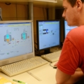 Ein Brautechniker überwacht und steuert industrielle Brauprozesse an mehreren Computern.