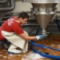Ein Brau- und Getränketechniker arbeitet in einer Brauerei und bedient eine Anlage zum Brauen.
