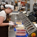 Auf dem Bild ist eine Chocolatières, die in einer Schokoladenmanufaktur Zutaten für die Herstellung von Schokoladen vorbereitet.
