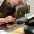 Eine Chocolatières dekoriert Schokolade in einer Chocolaterie.