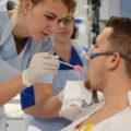 Auf dem Bild betreuen diplomierte Gesundheits- und Krankenpflegerinnen einen Patienten.
