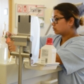 Eine diplomierte Gesundheits- und Krankenpflegerin in Arbeitskleidung arbeitet an einem medizinischen Gerät.