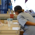 Eine diplomierte Gesundheits- und Krankenpflegerin in der Geriatrie kümmert sich um eine Patientin in einem Krankenhauszimmer.