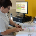 Eine diplomierte Gesundheits- und Krankenpflegerin arbeitet mit einem Computer und überprüft Dokumente.