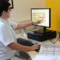 Eine diplomierte Gesundheits- und Krankenpflegerin arbeitet an einem Computer.