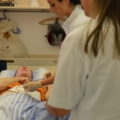 Das Bild zeigt diplomierte Gesundheits- und Krankenpflegerinnen, die sich um einen Patienten kümmern.