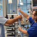 Auf dem Bild sind zwei diplomierte Gesundheits- und KrankenpflegerInnen zu sehen, die an medizinischen Geräten arbeiten.