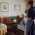 Eine diplomierte Gesundheits- und Krankenpflegerin kümmert sich um eine ältere Person in ihrem Zuhause.