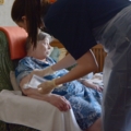 Das Bild zeigt eine diplomierte Gesundheits- und Krankenpflegerin, die sich um eine ältere Person kümmert.