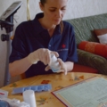 Eine diplomierte Gesundheits- und Krankenpflegerin sortiert Medikamente im Zuhause einer Patientin.