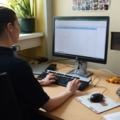 Eine diplomierte Gesundheits- und Krankenpflegerin arbeitet am Computer und gibt Daten in eine Tabelle ein.