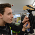 Auf dem Bild ist eine Person zu sehen, die an einem Fahrrad arbeitet, was auf eine Tätigkeit im Bereich Sportartikelverkauf oder -wartung hindeutet.