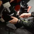 Ein Sportartikelverkäufer hilft dabei, Skistiefel anzupassen.