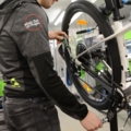 Ein Sportartikelverkäufer wartet ein Fahrrad in einer Werkstatt.