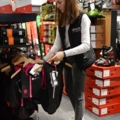 Eine Verkäuferin in einem Sportgeschäft sortiert Kleidung.