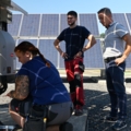 Das Bild zeigt ElektroenergietechnikerInnen, die an einer Solaranlage arbeiten.