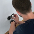 Ein Elektroenergietechniker installiert eine Steckdose in einer Wand.