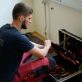 Ein Elektroenergietechniker sortiert Werkzeuge in einem Werkzeugkoffer.