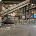 Das Bild zeigt einen Recyclingbetrieb, in dem Müll sortiert und verarbeitet wird.