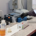 Auf dem Bild ist ein Entsorgungs- und Recyclingtechniker zu sehen, der in einem Labor chemische Proben analysiert.