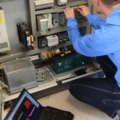 Ein Elektroenergietechniker arbeitet an der Verkabelung und Konfiguration eines Schaltschrankes.