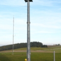 Ein Elektroenergietechniker klettert gesichert an einem Windradmast hoch.