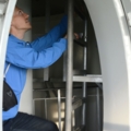 Ein Elektroenergietechniker klettert eine Leiter in einem Windrad hinauf.