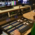 Das Bild zeigt eine Medienmanagement-Studierende, die in einem Fernsehstudio an einem Video-Mischpult arbeitet.