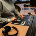 Das Bild zeigt eine Medienmanagement-Studierende, die in einem Fernsehstudio an einem Video-Mischpult arbeitet.