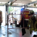 Das Bild zeigt eine Feuerwehrwache mit Einsatzfahrzeugen und Ausrüstung.