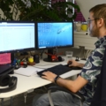 Ein Gamedesigner arbeitet an einem Computerarbeitsplatz mit zwei Monitoren.