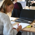 Eine Studierende des Studiengangs Gesundheits- und Pflegemanagement macht Notizen in einem Seminarraum an der FH.