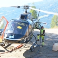 Ein Pilot betankt einen Hubschrauber in einer bergigen Umgebung.