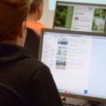 Auf dem Bild ist eine Immobilienkauffrau zu sehen, die Inserate auf einem Computer recherchiert.