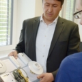 Ein Immobilienkaufmann präsentiert verschiedene Geräte der Haustechnik.