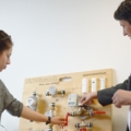 Zwei Immobilienkaufleute diskutieren und zeigen auf ein Heizsystem-Display.