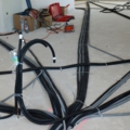 Das Bild zeigt Kabel und Rohre, die auf einer Baustelle von Installations- & GebäudetechnikerInnen verlegt werden.