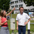 Eine Journalistin führt ein Interview mit einem Mikrofon im Freien durch.