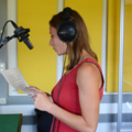 Das Bild zeigt eine Journalistin in einem Tonstudio, die einen Bericht aufnimmt.