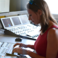 Eine Journalistin arbeitet in einem Radiostudio an einem Mischpult.
