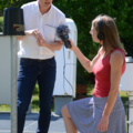 Eine Journalistin führt ein Interview mit einem Mann, während sie ein Mikrofon hält.