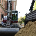 Auf dem Bild ist eine Baustelle zu sehen, auf der ein Kran- und Baumaschinenführer arbeitet.
