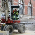 Ein Kran- und Baumaschinenführer bedient einen Bagger auf einer Baustelle.