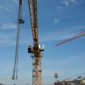 Auf dem Bild ist ein Baukran auf einer Baustelle zu sehen, der für Bauarbeiten eingesetzt wird.