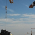 Das Bild zeigt Bauarbeiter auf einer Baustelle, die mit Kränen arbeiten.