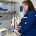 Das Bild zeigt eine Person in einem Labor, die mit chemischen Geräten arbeitet, was auf die Tätigkeiten eines/einer Chemielabortechnikers/in hinweist.