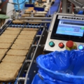 Das Bild zeigt eine Produktionslinie von Brotscheiben, die von LebensmitteltechnikerInnen analysiert werden.